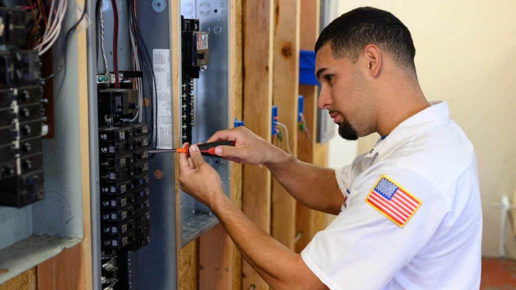 Technician installing new circuits in a home's electrical panel.