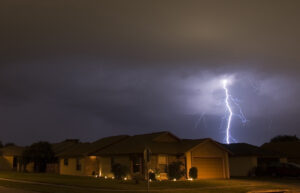 Lightning strike during a thunderstorm near residential neighborhood