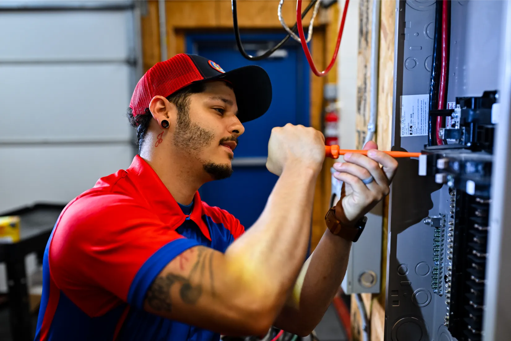 A pair of hands throwing circuit breaker at residential service panel while other hand holds a flashlight
